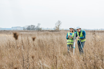 Surveyors with digital level and tablet working in field