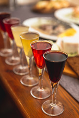 Set of glasses with different colored tinctures made on the basis of fruits and alcohol, a wonderful aperitif before the festive dinner