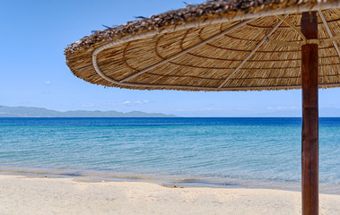 Umbrella on beautiful sand beach. Holidays, travel, vacation concept background.