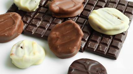 Handmade dark, white and milk chocolate on a white background. Top view