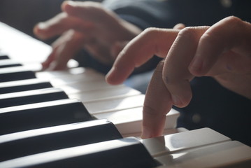 hands of child on piano keyboard