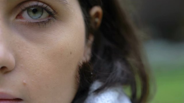 serious beautiful young woman with blue eye- half face