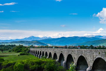 Montenegro, Historical building emperors bridge architecture of stone arches in green nature landscape of niksic city surrounded by mountains