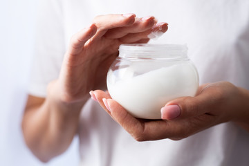 closeup of female hands applying hand cream.