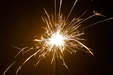 Sparkler in honor of the holiday on a black background. Merry Christmas