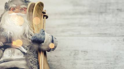 Skis in Santa Claus hand close up, isolated on the wooden background.