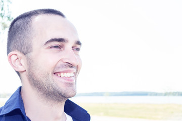 Obraz premium Attractive young man smiling, close up, copy space, toned