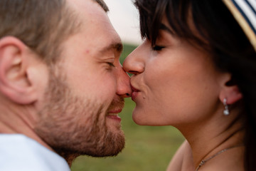 Girl kisses guy in the nose, a couple in love in nature