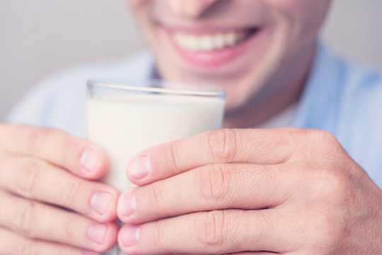 Man going to drink milk, men's hands, cropped image, toned