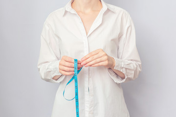 Woman with measuring tape, female hands, cropped image, copy space