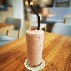 glass of milk on wooden table in cafe