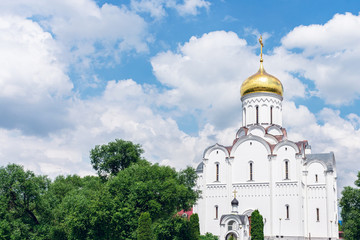 Fototapeta na wymiar The Orthodox Church against the blue sky with clouds, abstract background. The concept of religion, Church Of the Intercession of the blessed virgin in Minsk, cropped image, toned