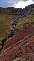 Obraz premium The Newlands Pass scenic valley in autumn with snow capped mountains. Popular destination in the Lake District, Cumbria, United Kingdom. 