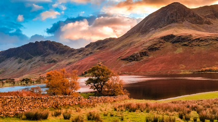 Autumn landscape of Buttermere lake in Cumbria, Lake District. Dramatic sunset in fall season colors and lake reflections in the North of England, UK. Popular destination in the mountains. 
