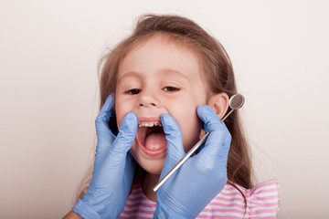 Dental medicine and healthcare - dentist examining little child girl patient open mouth showing...
