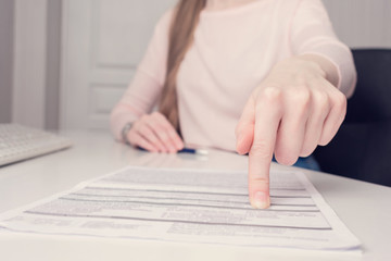 Woman boss points out mistake in documents, woman's hands, close-up, toned