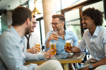 Funny conversation four businessmen while sit pub and drinking beer after work