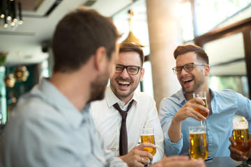 Funny conversation four businessmen while sit pub and drinking beer after work