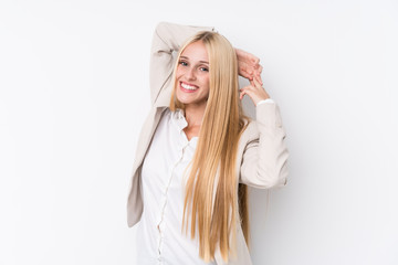 Young business blonde woman on white background stretching arms, relaxed position.