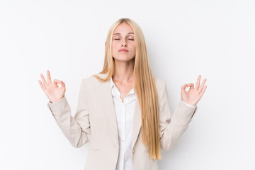 Young business blonde woman on white background relaxes after hard working day, she is performing yoga.