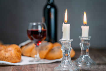 Shabbat Shalom. Challah bread, shabbat wine and candles on wooden table.