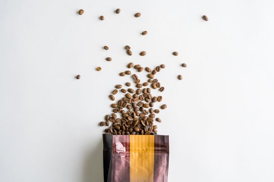 Overhead shot of a coffee pouring out of the bag on a white surface