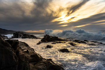 atardecer rocas olas oceano cielo
