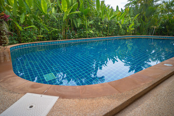 blue water in swimming pool beside the house.