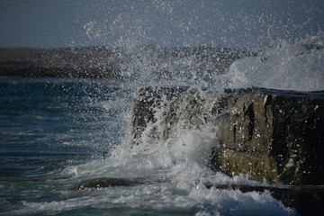 Naklejka premium Water Splash on Rocky Beach