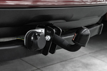 Metal hitch and electric plug on an SUV. Side view.