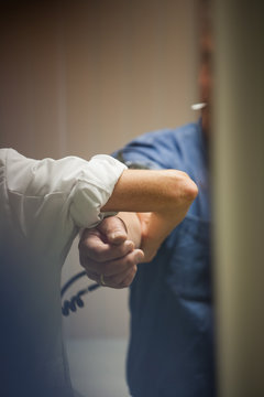 Cropped image of nurse checking blood pressure of patient at hospital