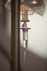 Close-up of IV drip against wall in hospital
