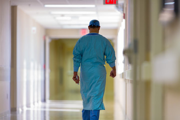 Rear view of surgeon walking in hospital corridor