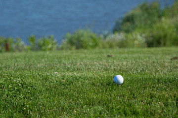 Beautiful green golf course with a golf ball in focus copy space mock up