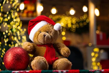 Christmas gift toys. Teddy bear gift from santa. Merry Christmas and Happy Holidays. Presents in room. Christmas teddy bear with christmas ball on beautiful decoration background. © Nikoletta