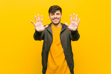 Young hispanic casual man showing number ten with hands.