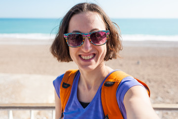 A girl takes a selfie on the beach.