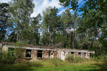The ruins of an old brick building in the woods. This barracks for soldiers was abandoned by the army after the Soviet Union finished. Russia, sunny summer day