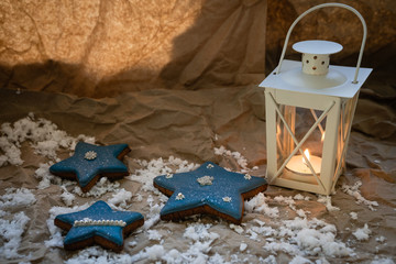 Star-shaped Christmas dessert on crumpled Kraft paper with candle lamp. Holiday mood for gifts.