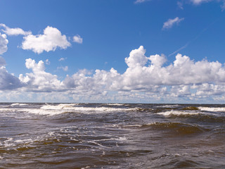 blurred foreground with sparkling waves, clouds and sea in the background