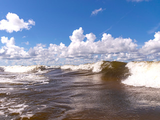 blurred foreground with sparkling waves, clouds and sea in the background