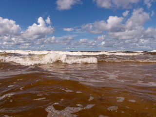 blurred foreground with sparkling waves, clouds and sea in the background