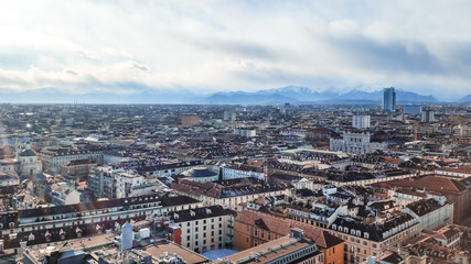 Fototapeta na wymiar Panoramic aerial top view cityscape of Turin in Italy; Overlooking historical buildings and landmarks with snow capped mountains in the background. 