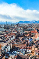 Obraz premium Panoramic aerial top view cityscape of Turin in Italy; Overlooking historical buildings and landmarks with snow capped mountains in the background. 