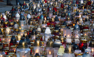 Monument and candles in the cemetery. All Saints Day in Poland. A lot of funeral candles.