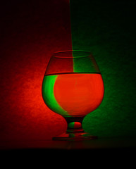 glass of wine on red and green background