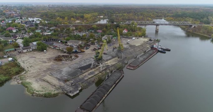 Large cranes in the port unload the barge with the material, port cranes work from the top