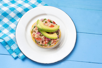 Mexican fish  ceviche with avocado on blue background