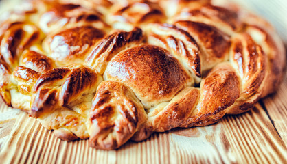 Homemade rustic twisted pie on a wooden background. Photographed close-up.
