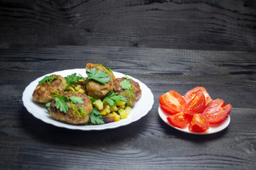 fried potatoes with vegetables and meatballs, top view, selective focus